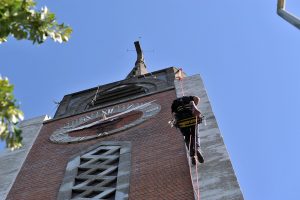 Un ouvrier escalade le clocher de l’église Saint-Stanislas-des-Blagis.