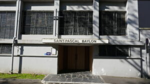 L’église, en face, en pied d’immeuble, tournant le dos à la rue.