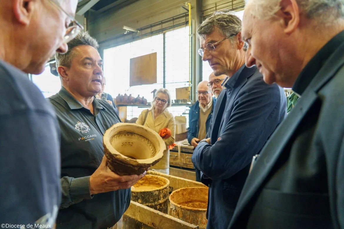 4 hommes autour d'un moule d'une cloche