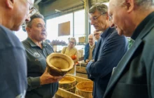 4 hommes autour d'un moule d'une cloche