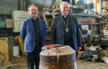 Curé et évêque devant le moule de la future cloche de Saint-Colomban